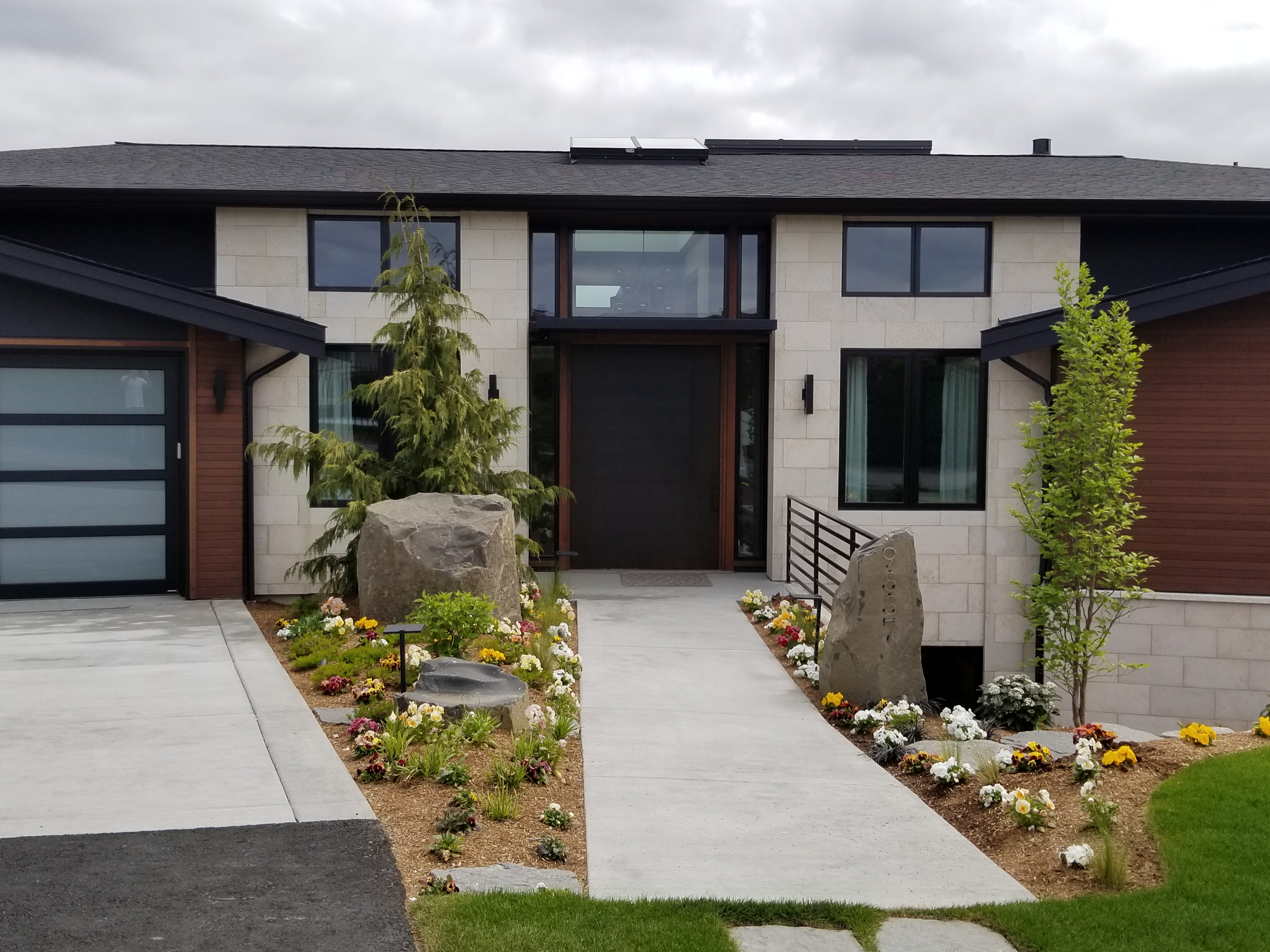 Modern home entry with light stone veneer and landscaping