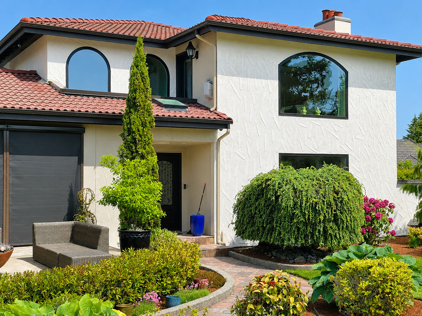 Finished white stucco exterior with red tile roof and garden landscaping